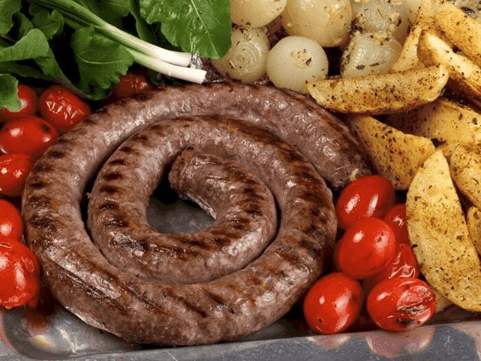 Món xúc xích nướng hình xoắn ốc kèm cà chua bi, hành và khoai tây, giảm giá trong thực đơn BBQ ngon miệng.