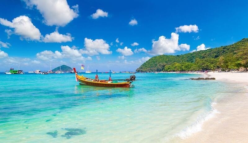 Bãi biển xanh biếc với thuyền gỗ truyền thống dưới bầu trời xanh, khung cảnh nhiệt đới tuyệt đẹp lý tưởng cho kỳ nghỉ.