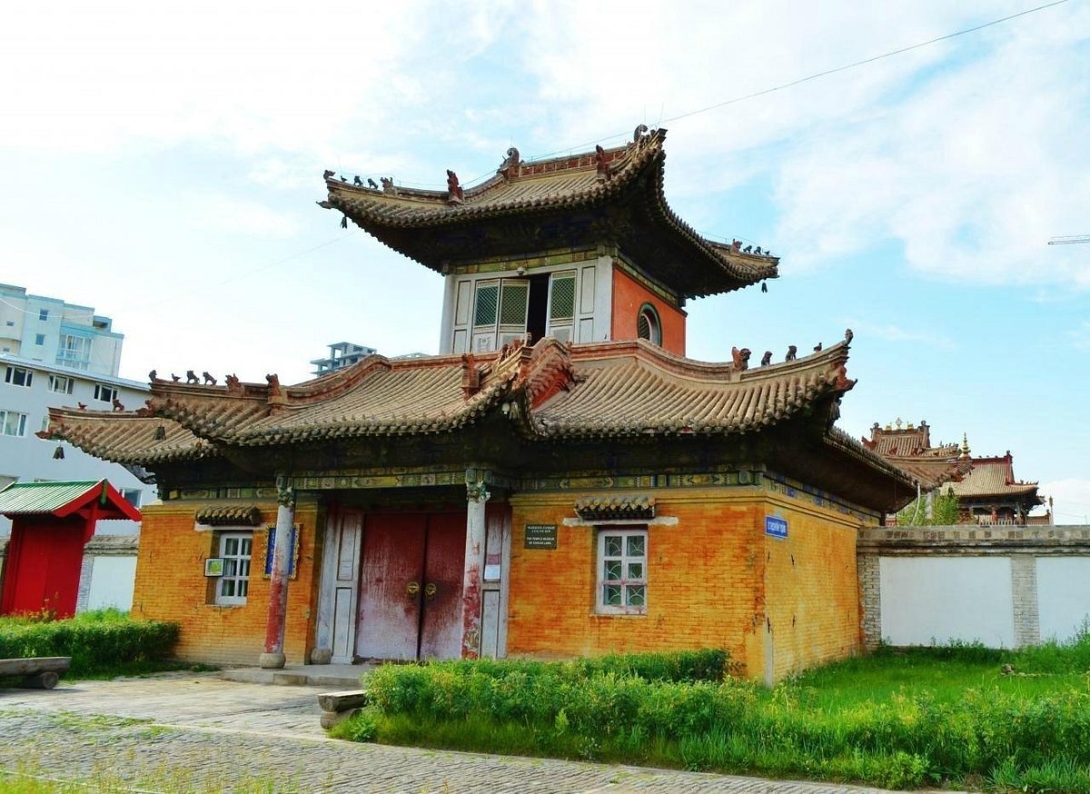 Một tòa nhà cổ điển với kiến trúc truyền thống và mái ngói cong, nằm trong khu vực đô thị hiện đại.