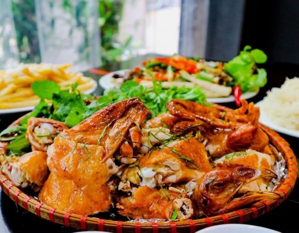 Món gà quay thơm ngon, da giòn rụm ăn kèm rau sống tươi ngon và đĩa khoai tây chiên vàng giòn hấp dẫn.