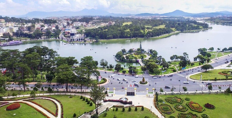 Hồ và công viên trung tâm thành phố Đà Lạt xanh mát, bao quanh bởi đồi núi và kiến trúc độc đáo.