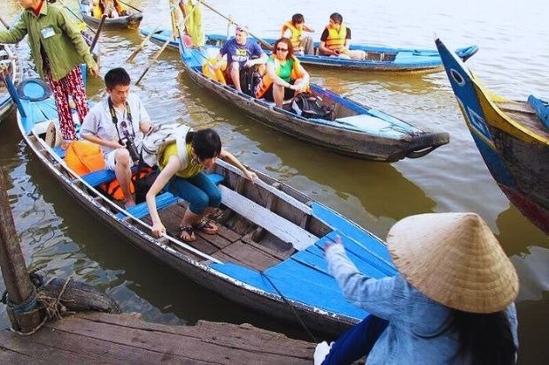 Du khách tham gia tour du ngoạn trên thuyền tại chợ nổi miền Tây Việt Nam, trải nghiệm văn hóa đặc sắc địa phương.