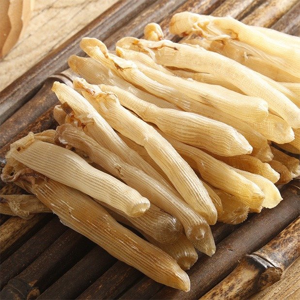 Củ tam thất bắc khô trên bề mặt gỗ, nguyên liệu dùng trong y học cổ truyền với nhiều lợi ích sức khỏe.